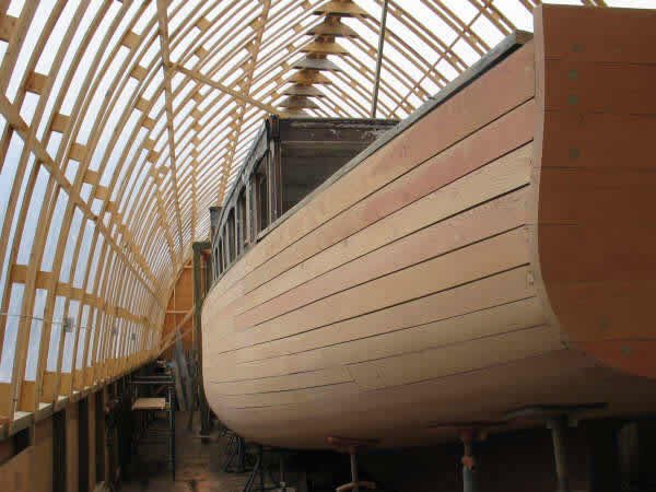 The hull in the restoration shed — rebuilt from the keel up